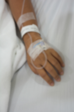 Blurred photo of The patient is lying on a bed in the hospital receiving intravenous chemotherapy.の写真素材