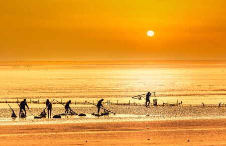 fishermen working on the sea during sunrise の写真素材