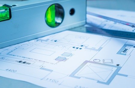 Architectural blueprints, blueprint rolls and a drawing instruments on the worktableの写真素材