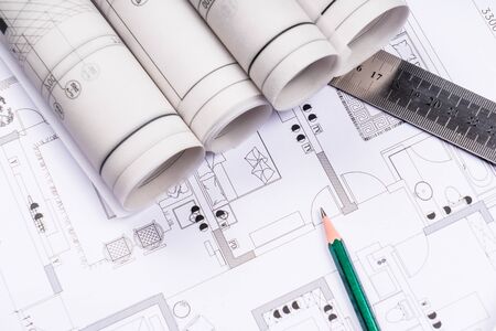 Architectural blueprints, blueprint rolls and a drawing instruments on the worktableの写真素材