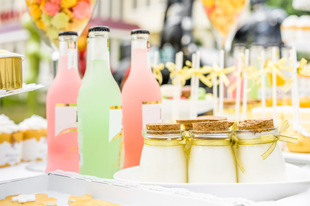 Table arrangement of colourful bottles and pastryの写真素材