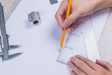 Interior designer works on a hand drawing sketch using color pencils, rule and rubber