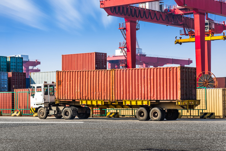 Highway bridge and truck transport container on the road to the port.