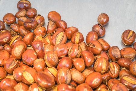 Delicious roasted chestnuts on the wooden background.の写真素材