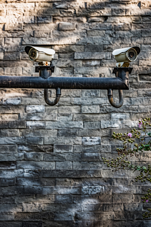 CCTV security camera front of a brick wall in city of China.の写真素材