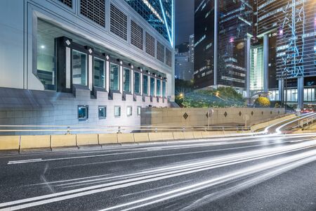 light trails on city street with cityscape at night in China.