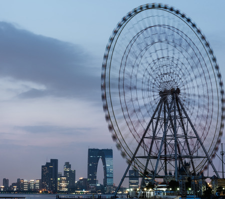 ferris wheel with cityscape in background in Suzhou,China.の写真素材