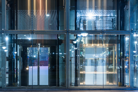 Glass Entrance Of modern office building at night in Shanghai,China.