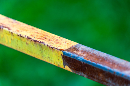 detail shot of old iron railing against green background.の写真素材