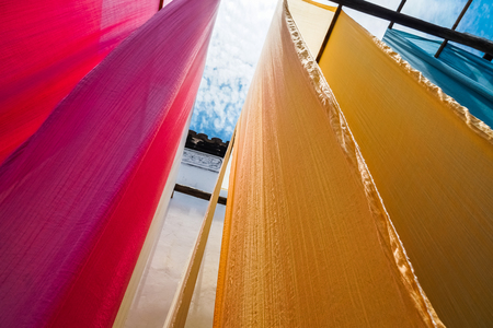 colorful fabric hanging to dry after traditional dye process,shot in Heng Dian Town,Zhejiang province of China.の写真素材