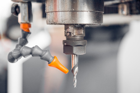 closeup of drilling machinery with cooling tube in factory,blurred background.