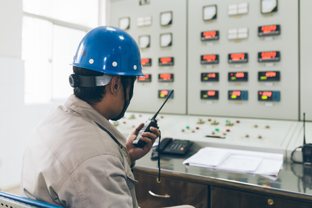 workers using walkie-talkie in control room of a factory.のeditorial素材