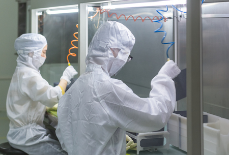 workers and machinery in a solar panel manufacturing industry factory.のeditorial素材
