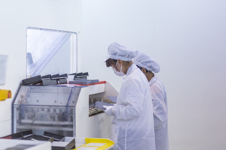 workers and machinery in a solar panel manufacturing industry factory.のeditorial素材