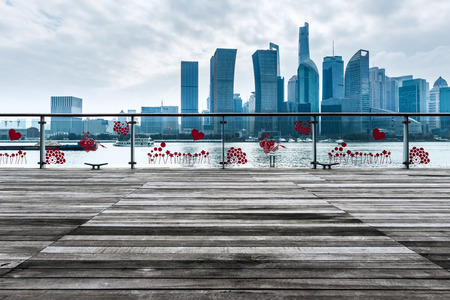 empty wooden platform with Shanghai skyline at night in background.