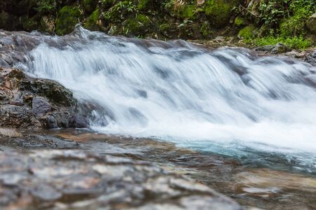 Stream Flowing Through Rocks in forest.