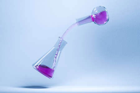 Pouring liquid between two laboratory flasks