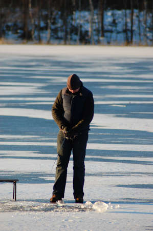 Long ice fisherman on frozen lakeの写真素材