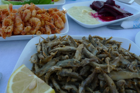 Fried anchovies and prawns on a plate with lemonの写真素材