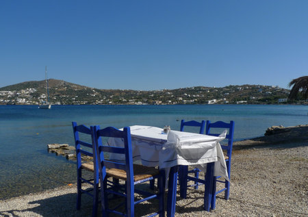 Table and chairs on the beach of the island of Leros, Greeceの写真素材