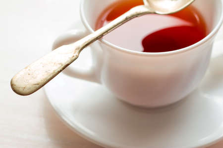 white china cup on  of black tea with silver teaspoonの写真素材