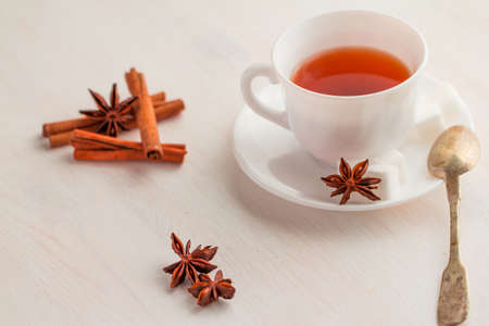white china cup on  of black tea with silver teaspoon and cubic sugar decorated with onise star flowerの写真素材