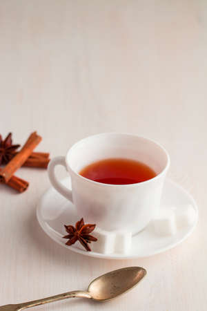 white china cup on  of black tea with silver teaspoon and cubic sugar decorated with onise star flowerの写真素材