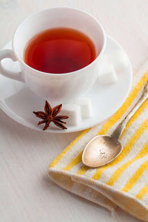 white china cup of black tea with teaspoon  on kitchen towelの写真素材