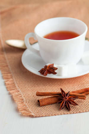white china cup on  of black tea with silver teaspoon on canvas tableclothの写真素材