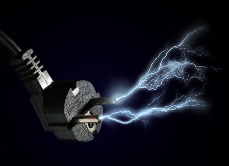 Plug and electric discharge over black background.の写真素材