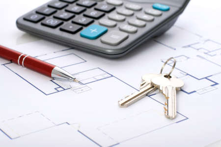 House plan, calculator and red pen over white.の写真素材