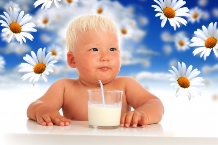 Baby drinks milk from glass.の写真素材