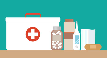 First aid kit with medical equipment and medications. Vector illustration in a flat style.のイラスト素材