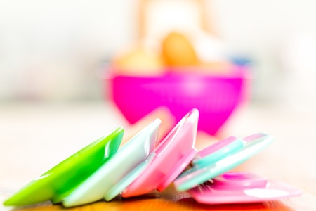 Close up view of colourful plastic kitchen utensils used for baking stacked on a kitchen counterの写真素材