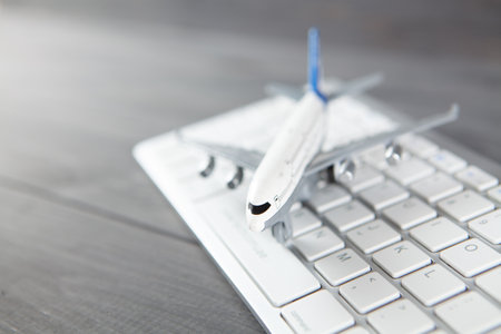 plane and keyboard. online purchase of airline tickets on a gray wooden tableの写真素材