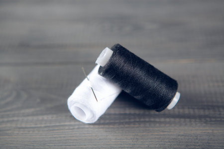 threads on the table. black and white on a gray wooden table
