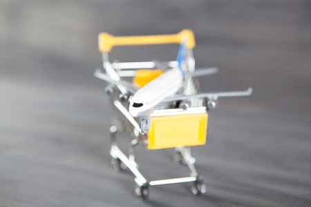 the plane in the basket. airline ticket purchase concept on gray wooden background