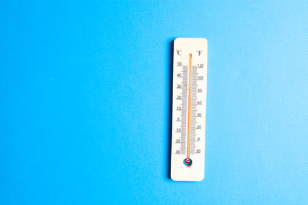 wooden thermostat on blue backgroundの写真素材