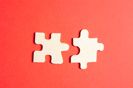 two puzzle pieces on a red background