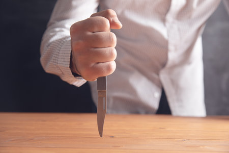 the man stabbed the table .の写真素材