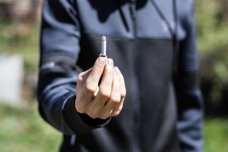 a man smokes in the park during the dayの写真素材