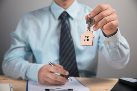 holding house keys on gray backgroundの写真素材