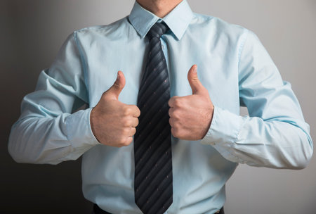 man showing thumb up on gray backgroundの写真素材