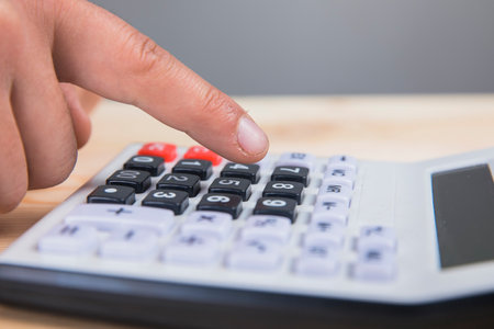 a man counting on a calculatorの写真素材