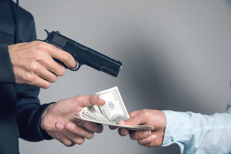 man threatens with a gun and takes money from a businessmanの写真素材