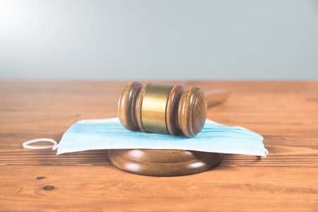 court gavel with medical mask on the wood tableの写真素材