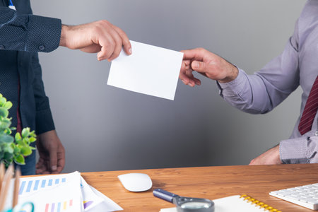 people exchange envelopes at their desk .