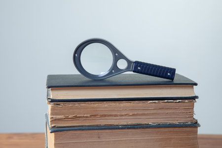 old books with magnifying glass on the table