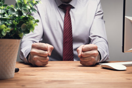 the man put his fists on the desk .の写真素材