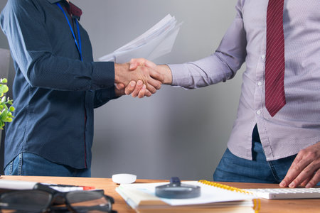 office workers shaking hands at the desktop .の写真素材